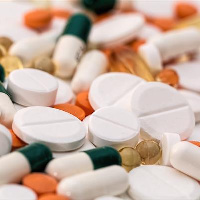 Assorted medicinal capsules and tablets in green, orange and white