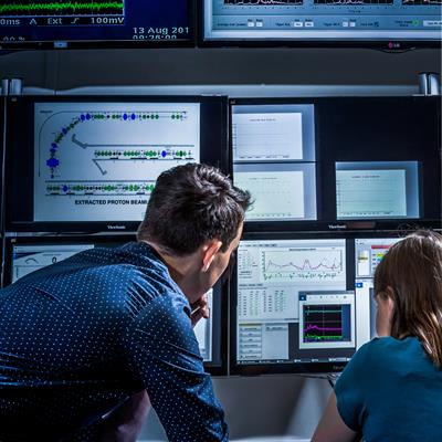 Two people working on a computer in the ISIS main control room
