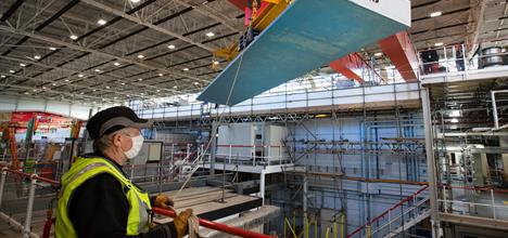Roof lintel being craned off, with staff member directing