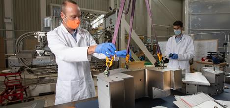 Staff members lifting parts of the new berylium reflectors