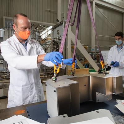 Staff members lifting parts of the new berylium reflectors