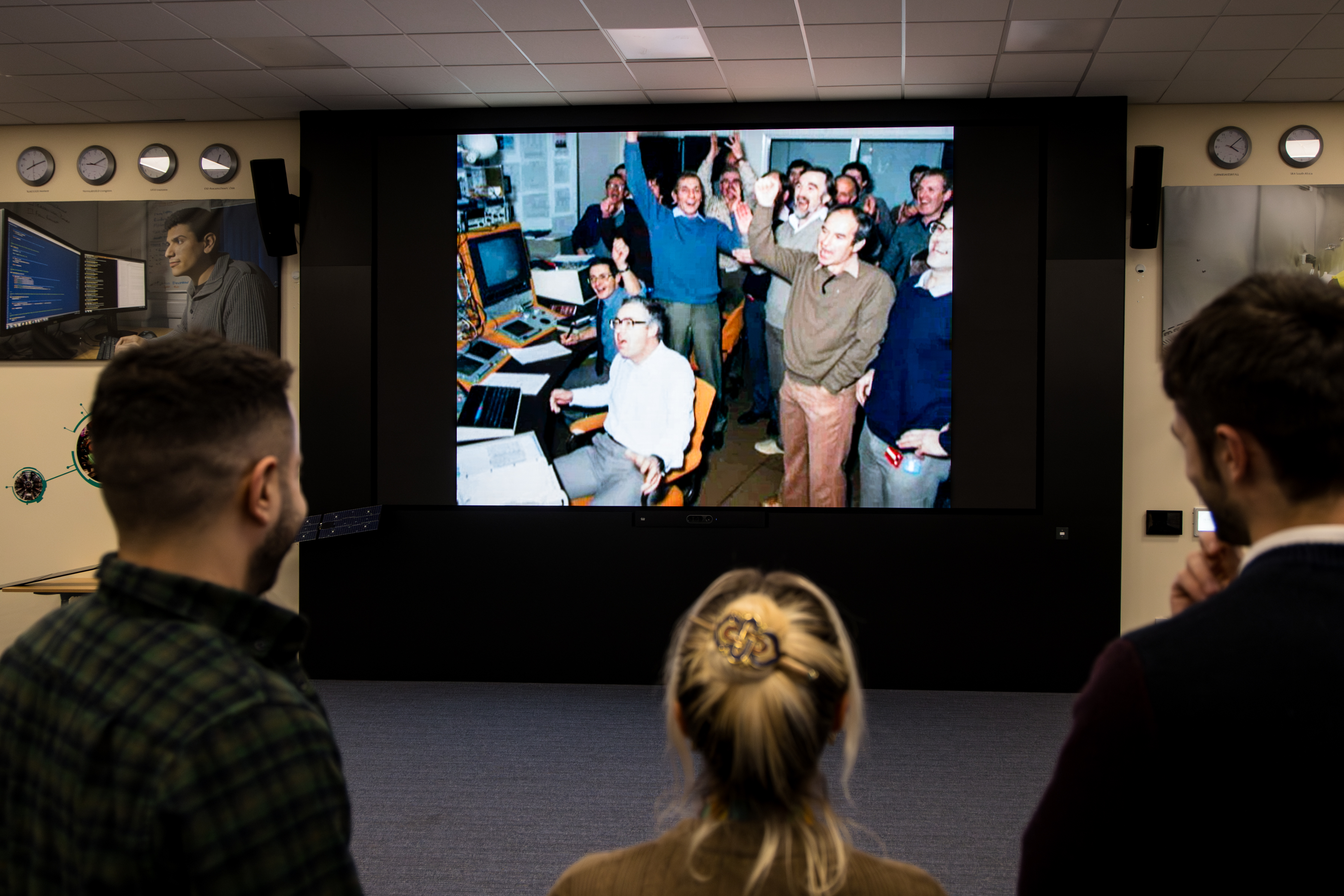 23EC9385 Isis staff meeting - staff looking at launch photo.jpg